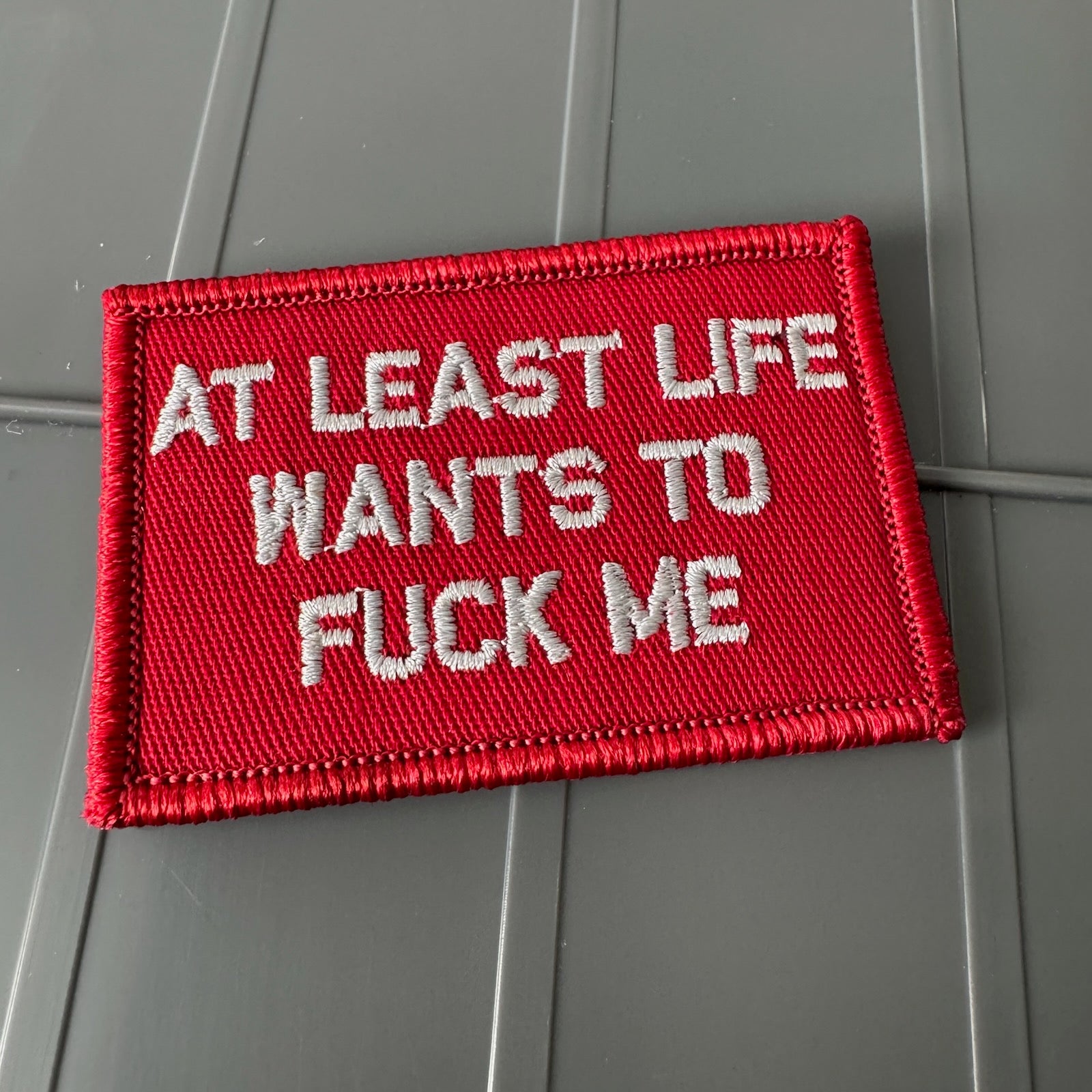As Seen on Socials - At Least Life Wants To Fuck Me - Red w/Silver