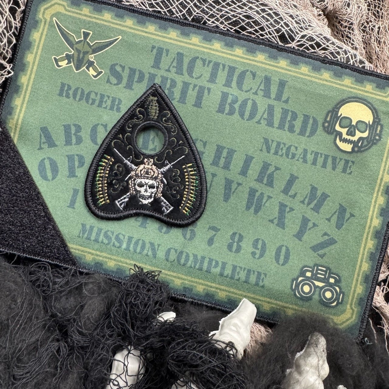 Tactical spirit board with a skull and crossbones patch on a green background